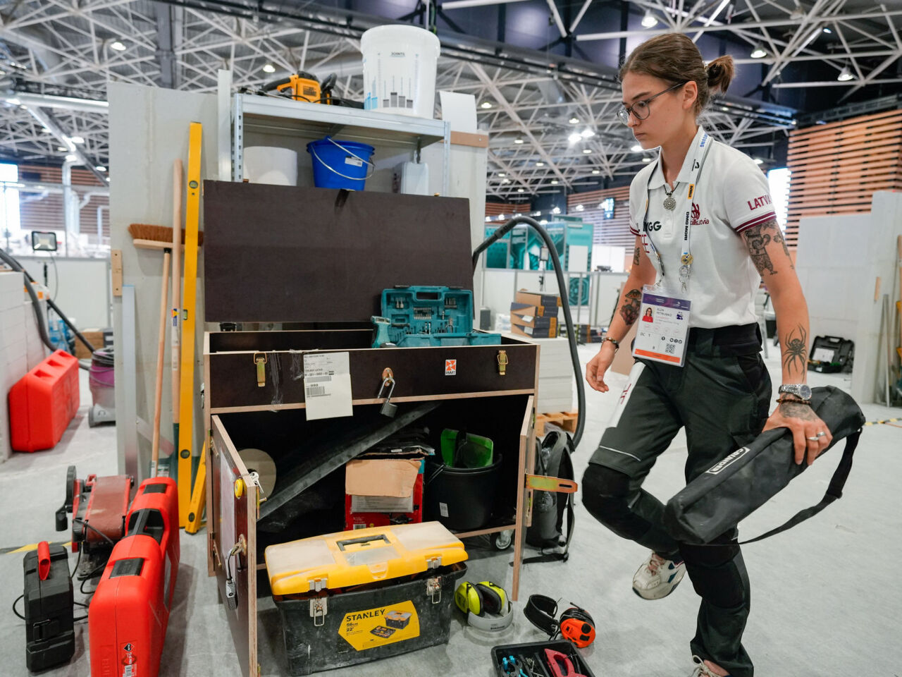 A Competitor from Latvia carrying tools during familiarization day at WorldSkills Lyon 2024.
