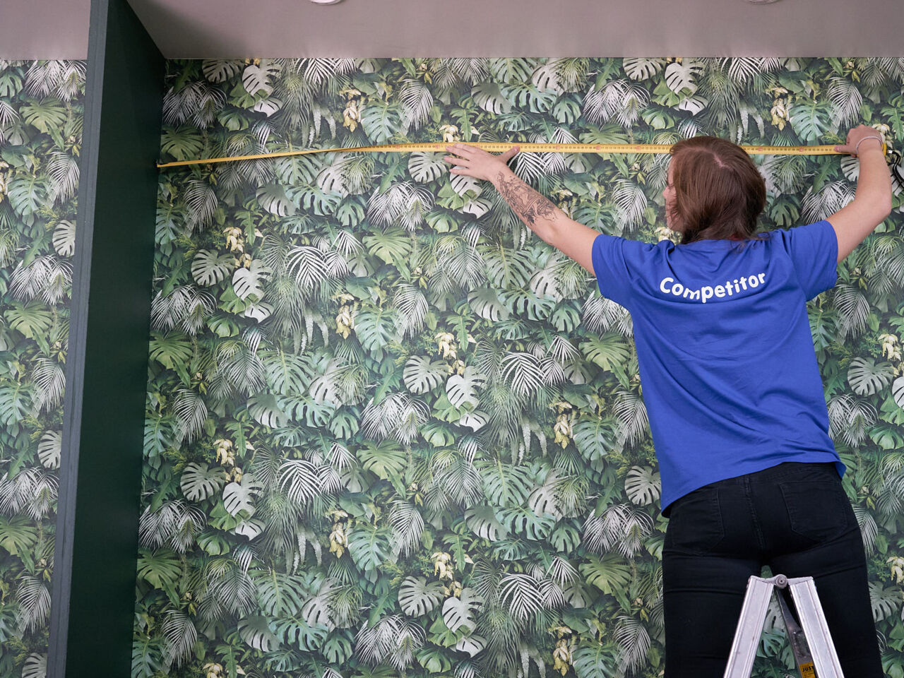 A competitor standing a step ladder using a measuring tape during the WorldSkills Italy nationals in Bolzano, South Tyrol.
