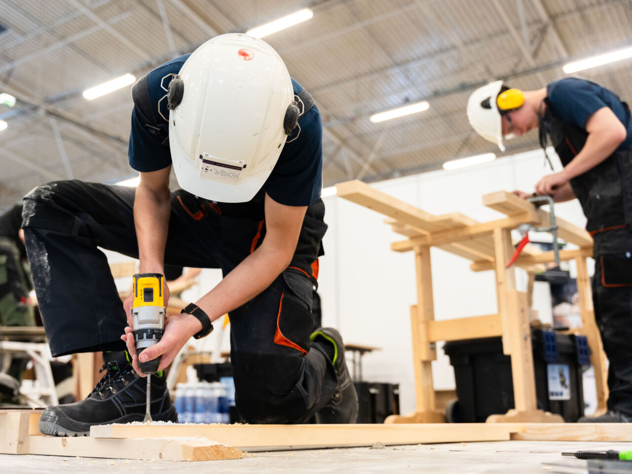 Two Competitors wearing hard hats drilling and measuring at the Estonian Exhibition Centre in Tallinn during the Young Master Skills Festival in May 2024.

 
