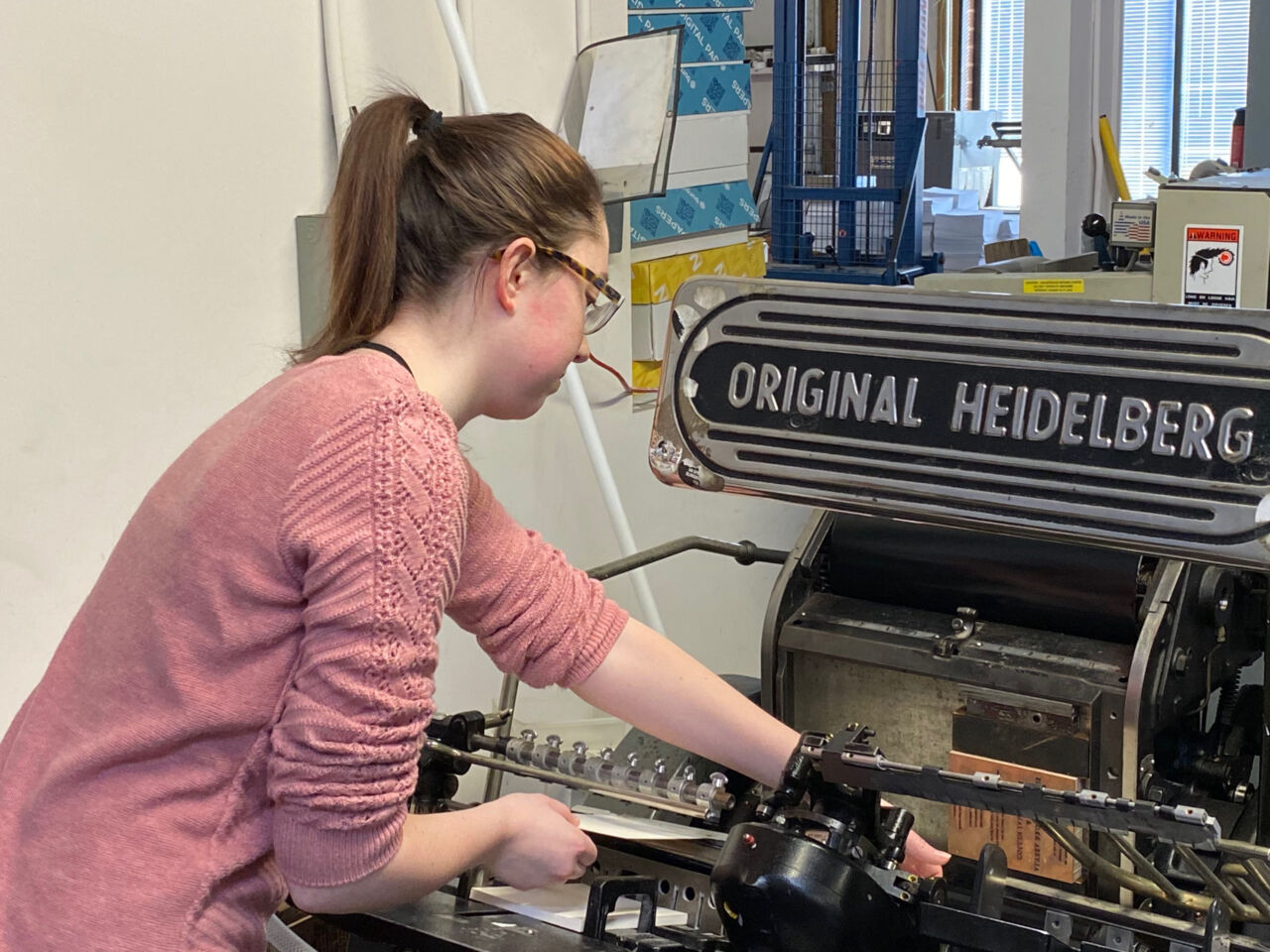 SkillsUSA Champion Brittany Kerr working with an old printing press.