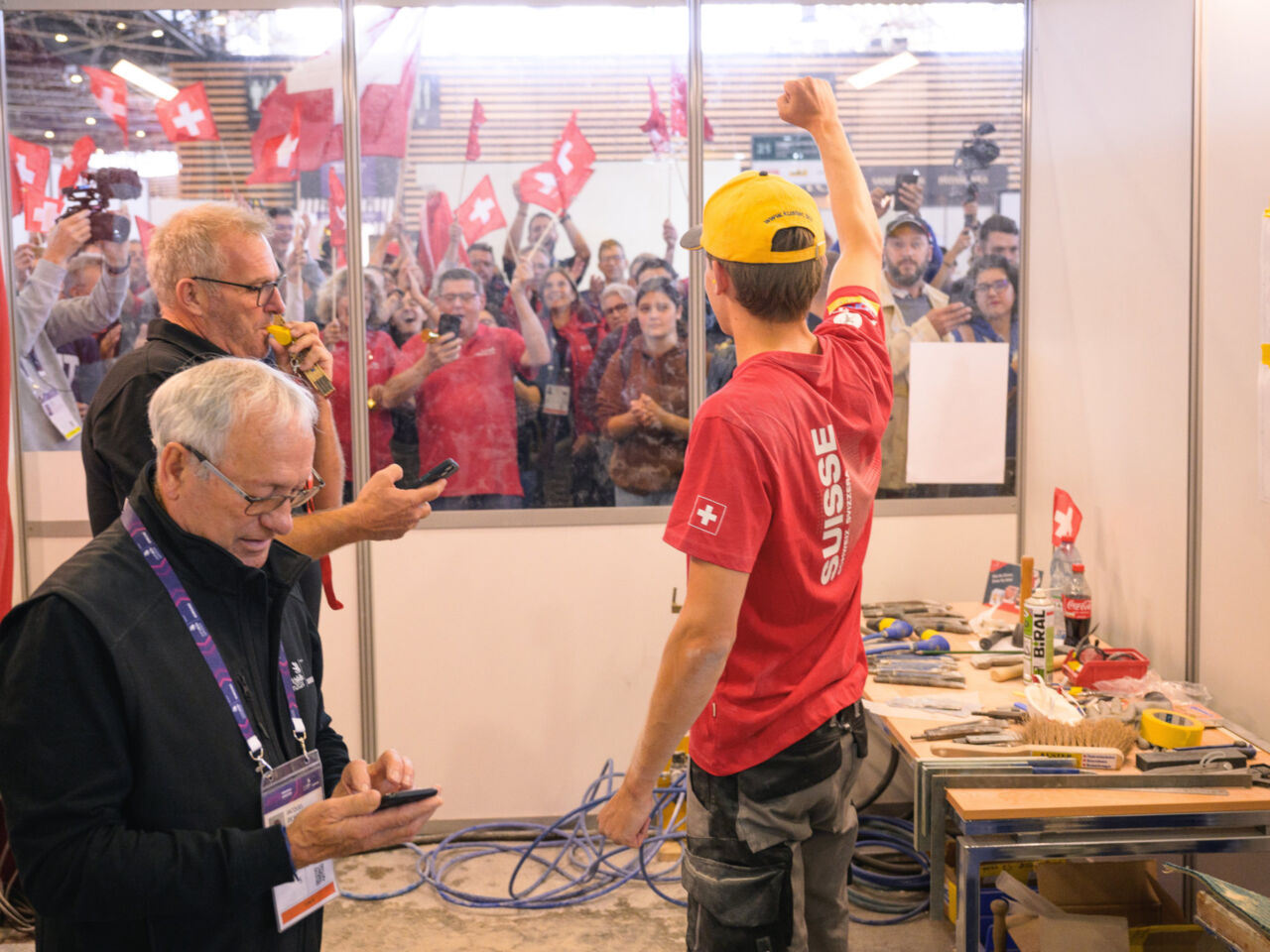 A competitor from Switzerland celebrates to a crowd of spectators as the competition ends at WorldSkills Lyon 2024.