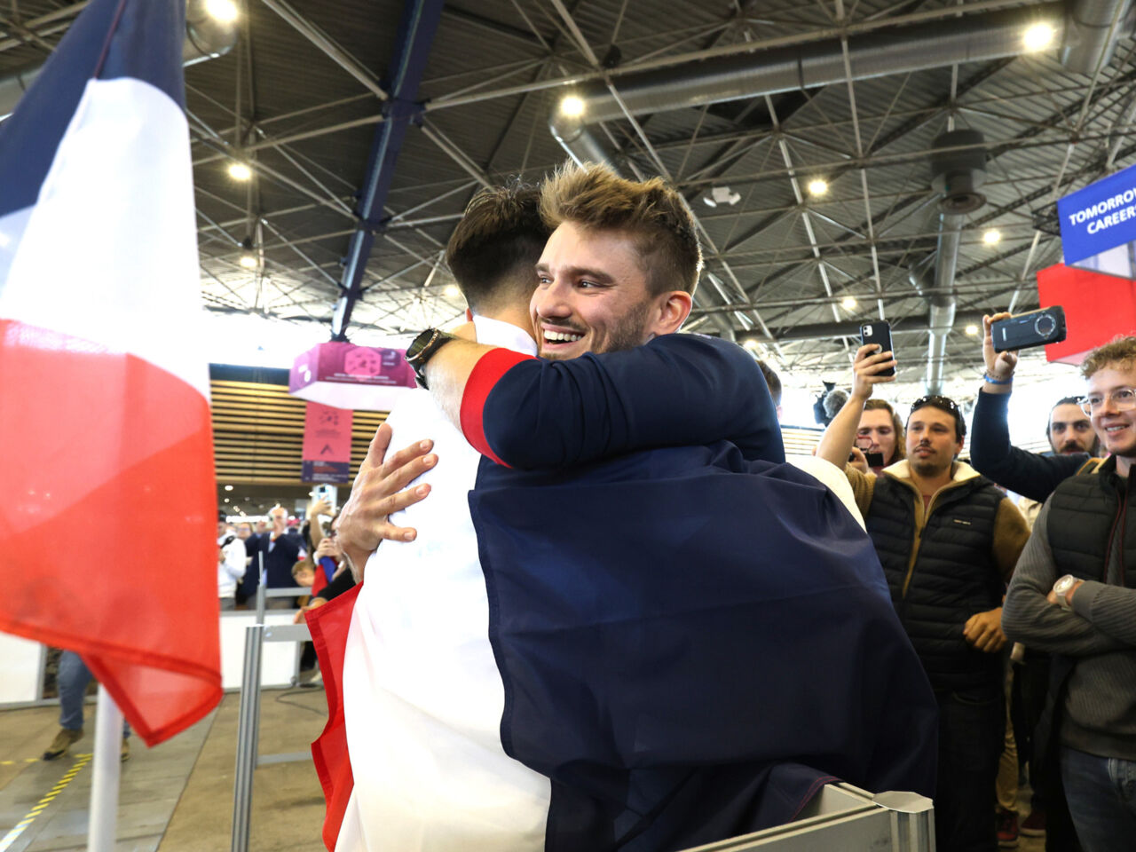 A Competitor in Electrical Installations being hugged on the last day of WorldSkills Lyon 2024.