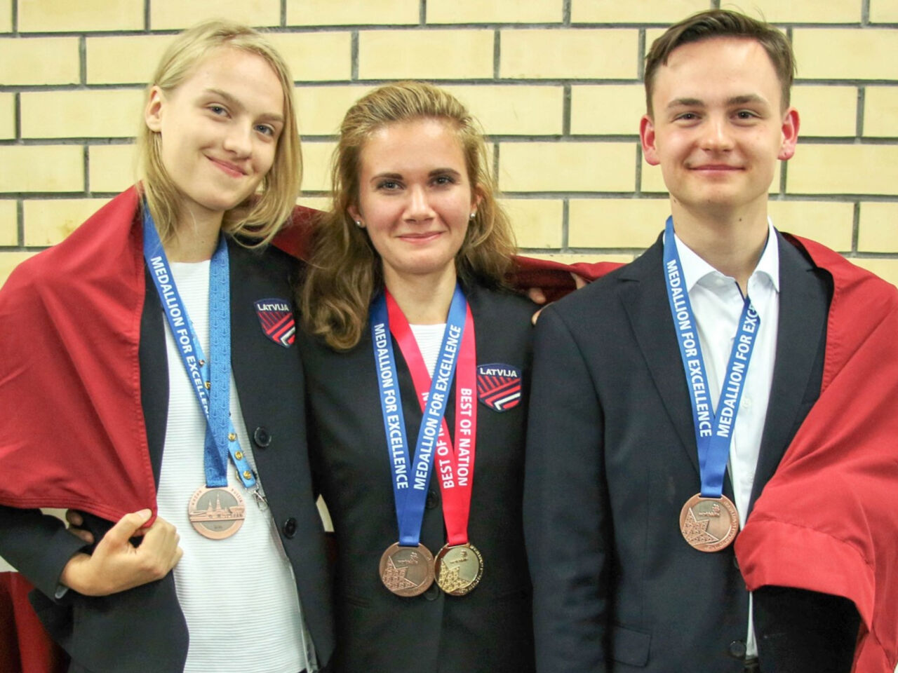 On the right is Latvian chef Nils Gēvele, holding his WorldSkills medal, standing next to two other female competitors.