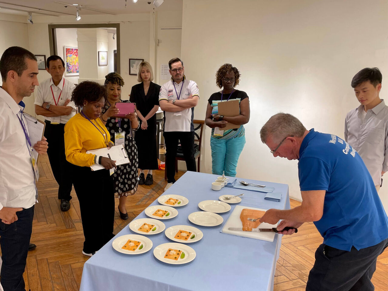 A WorldSkills expert cuts salmon on a table in front of spectators, as part of a Skills Development Workshop for Restaurant Service, one of events held alongside the Skills Cooperation Symposium in July 2023.