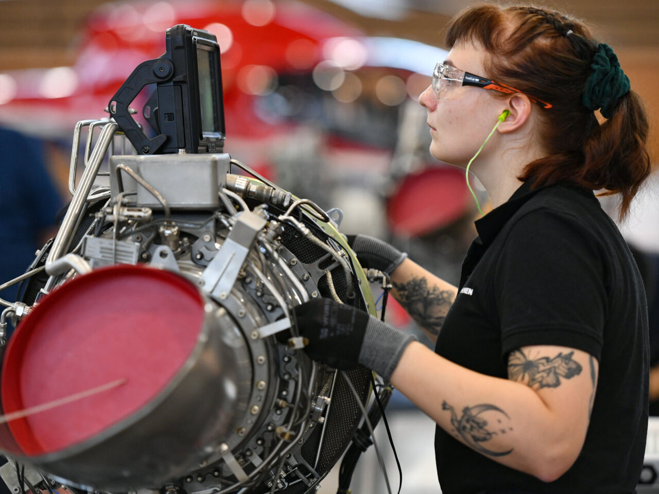 Piia Pirhonen, Competitor in Aircraft Maintenance from Finland examines a diagnostic screen on top of an aircraft engine at WorldSkills Lyon 2024.