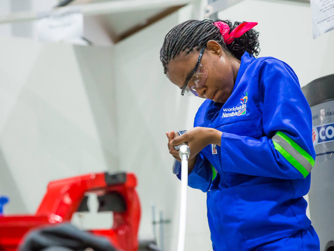 A female competitor working with pipes at a skill competition.