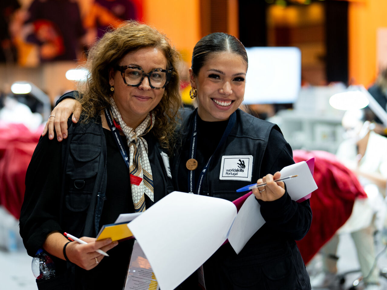 Two women stand with clipboards at WorldSkills Portugal’s 46th National Skills Competition from 12 to 16 November 2024. 