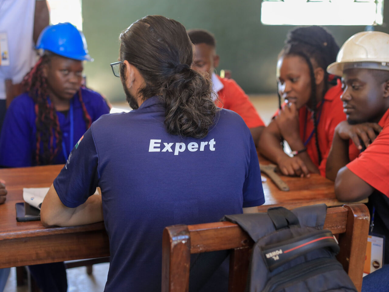 Chintan Daiya from India, Chief Expert in Plumbing Heating sitting at a desk with a group of students. 