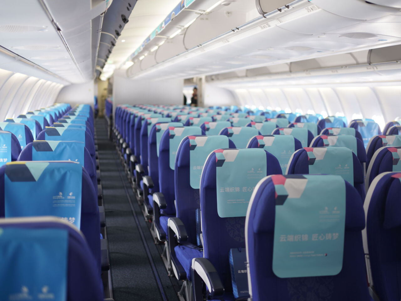 Inside the WorldSkill-themed aircraft for WorldSkills Shanghai 2026 which includes headrest covers, luggage bins, and tray table decals